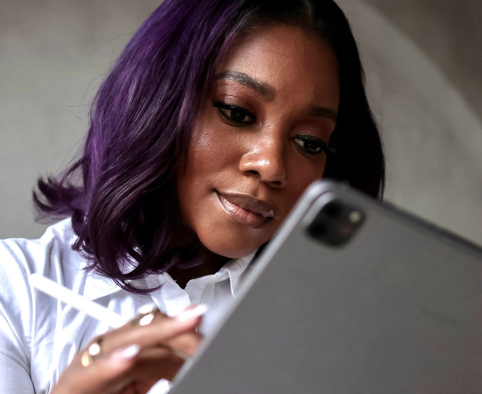Eye-level view of a person working on a laptop with branding materials spread out