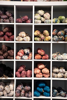 Different coloured yarns stacked in cube shelving