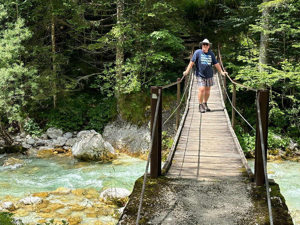 There are lots of wooden bridges across the Soca River this is one of them with Michael skipping across