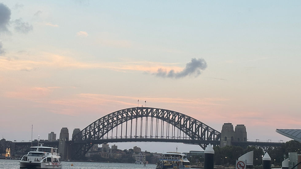 A hazy pink sky as the sun sets in Sydney Harbour