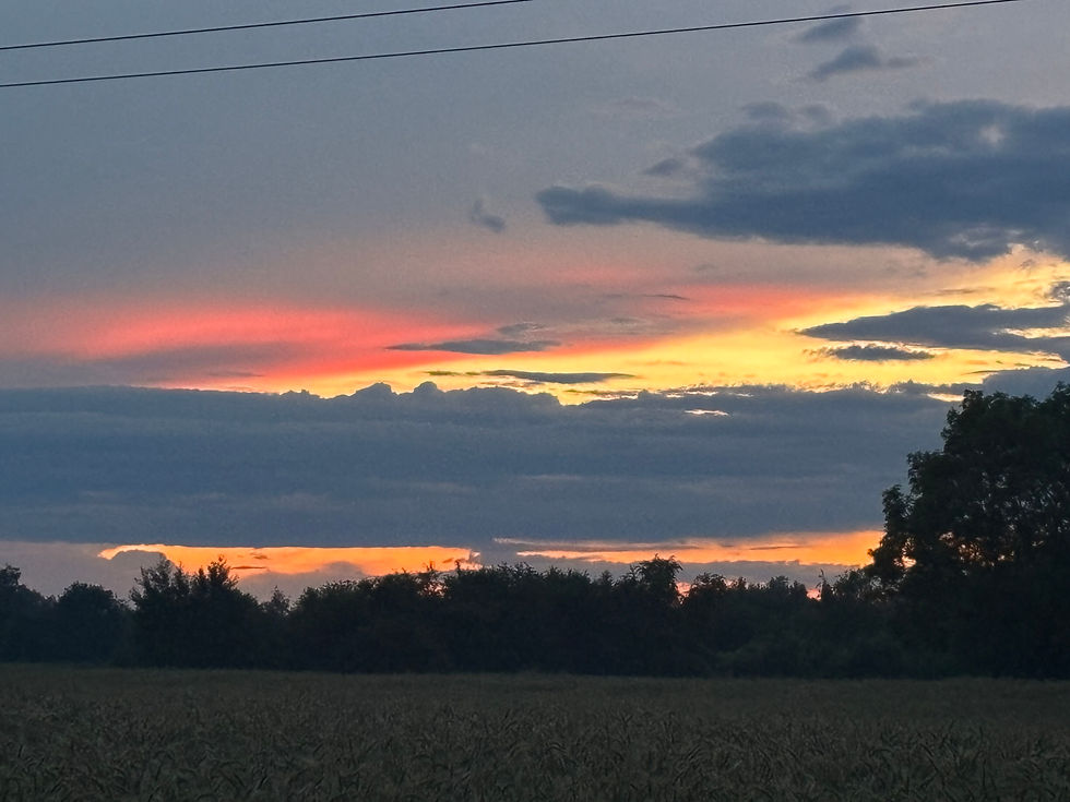 stormy looking skies at sunset with black clouds and orange and red background