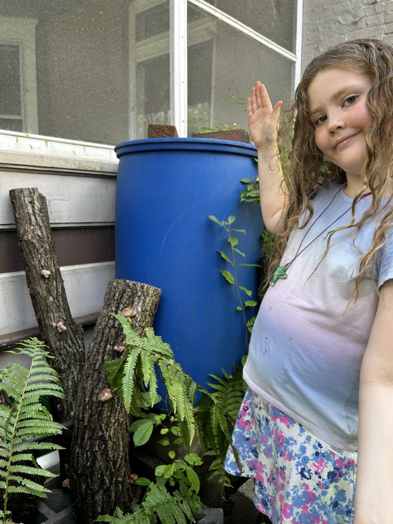 Emma poses with shiitake logs.