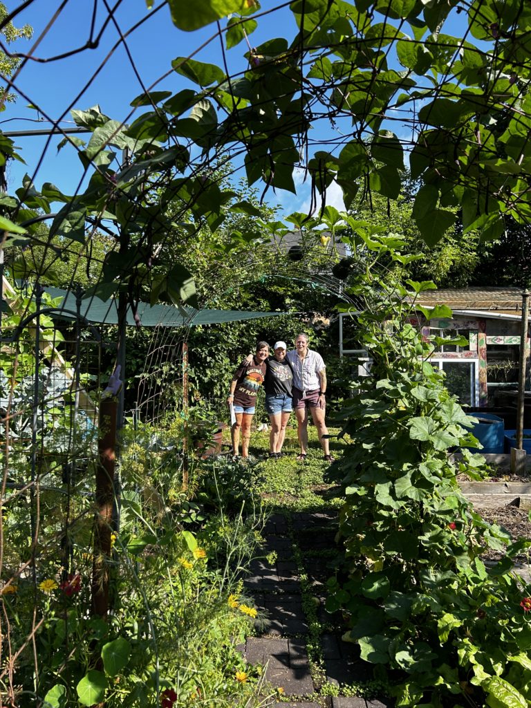 Chellsea (right) and two garden "tourists" pose behind Chellsea's trellis.