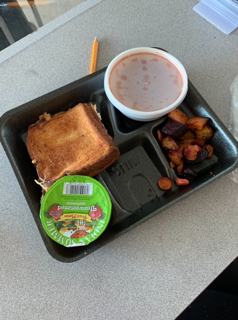 Lunch tray with a grilled cheese, tomato soup, applesauce and the medley of roasted vegetables.
