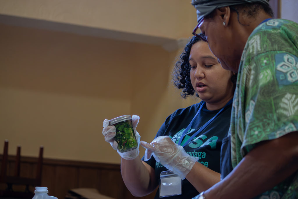 Kayla Miller (left) shows her pickles off to pickle expert, Marva Hudson (right). (Credit: So Nishitani)