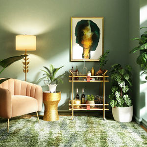 A cozy living room with a beige armchair, gold side table, and bar cart. Green plants, abstract art, and a lamp add a serene vibe.