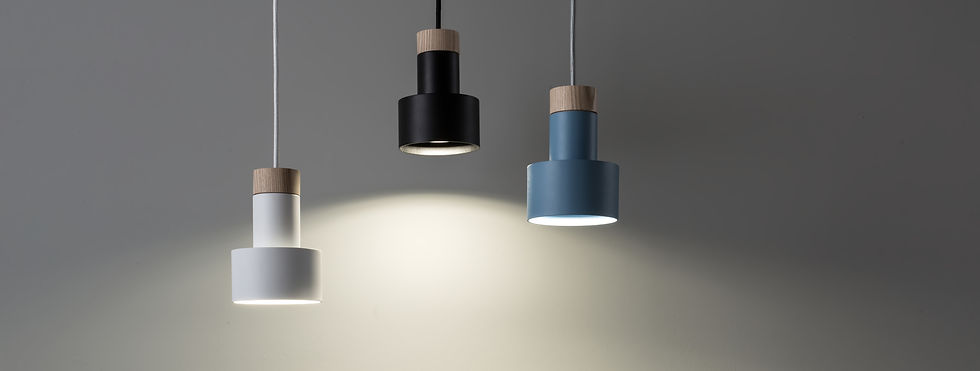 Three pendant lamps in white, black, and blue hang against a gray background, casting soft light below. Modern and minimalist design.