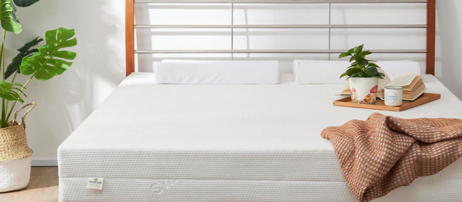 Minimalist bedroom with a natural latex mattress, wooden bed frame, and cozy blanket