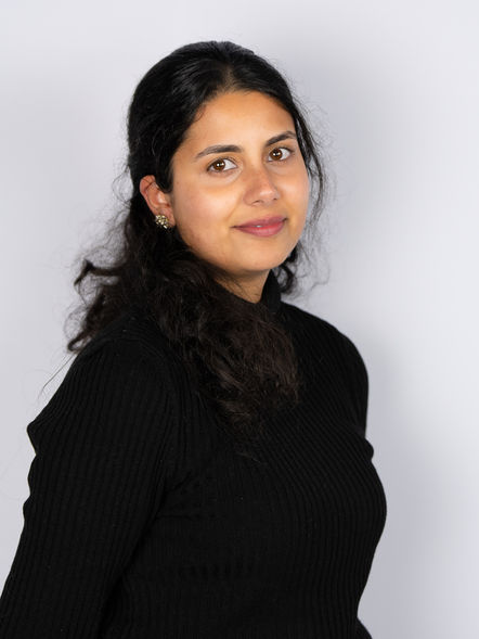 Confident young professional woman in black attire, corporate headshot for business profile and leadership branding.