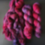 Skeins of deep red and purple hand dyed yarn