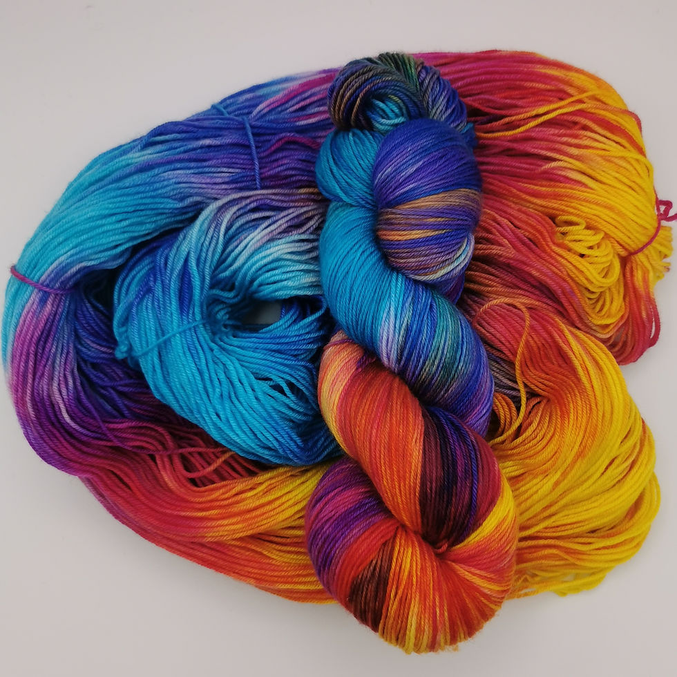 Vibrant multicolored merino wool yarn skeins in a rich palette of blue, purple, red, and yellow, on a white surface