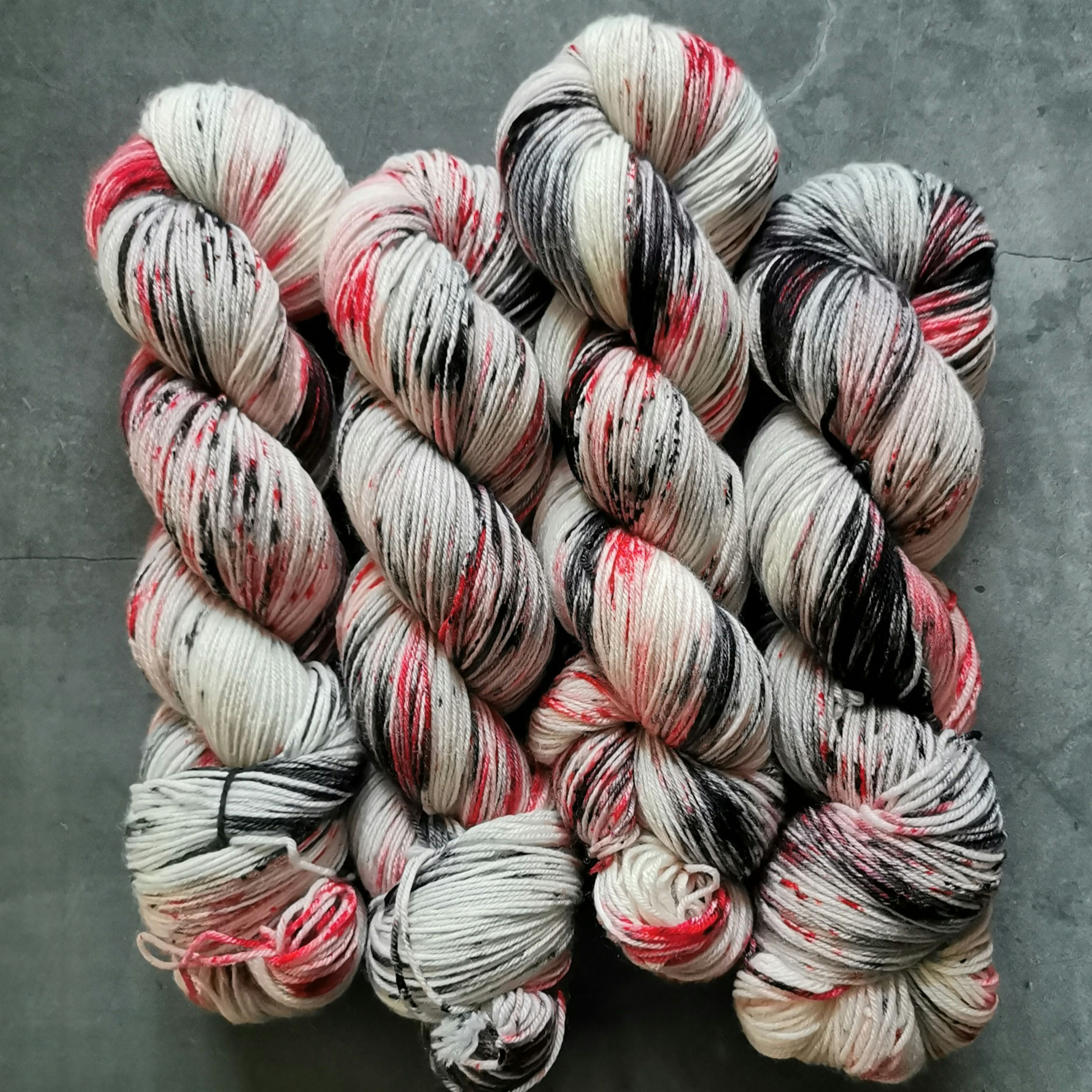 Lady Macbeth yarn hand-speckled in black, grey, and red