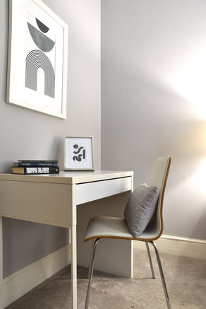 Desk with chair and framed art in a modern interior design