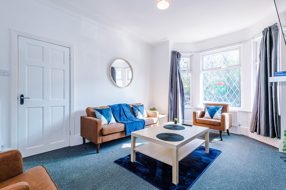 Living room with brown sofa, coffee table, and blue rug. Interior Home