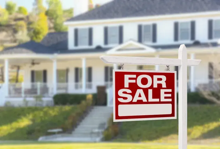 For Sale sign in front of a home illustrating the benefits of roof cleaning before selling your home.