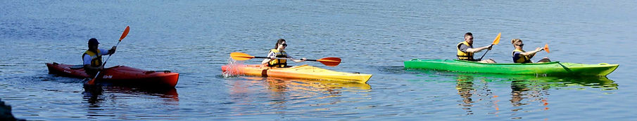 Menschen in drei Kajaks auf dem Wasser