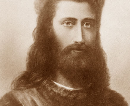 Retrato sépia do Mestre Kuthumi, homem barbudo de cabelo longo, expressão séria, em fundo neutro.
