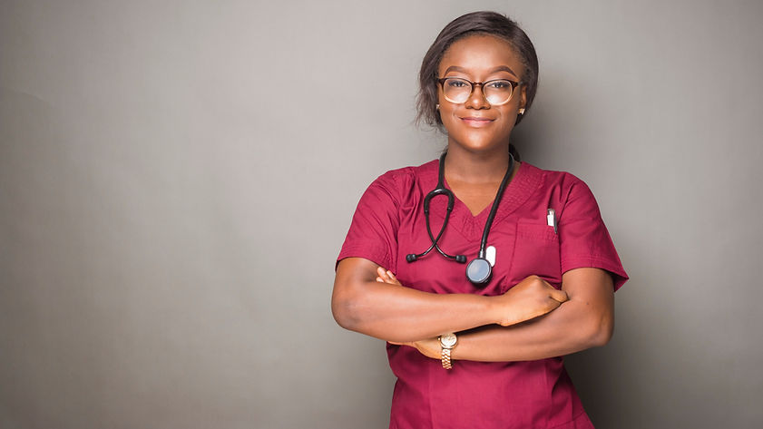portrait of a young female african doctor posing with arms folded, wearing glasses and ste