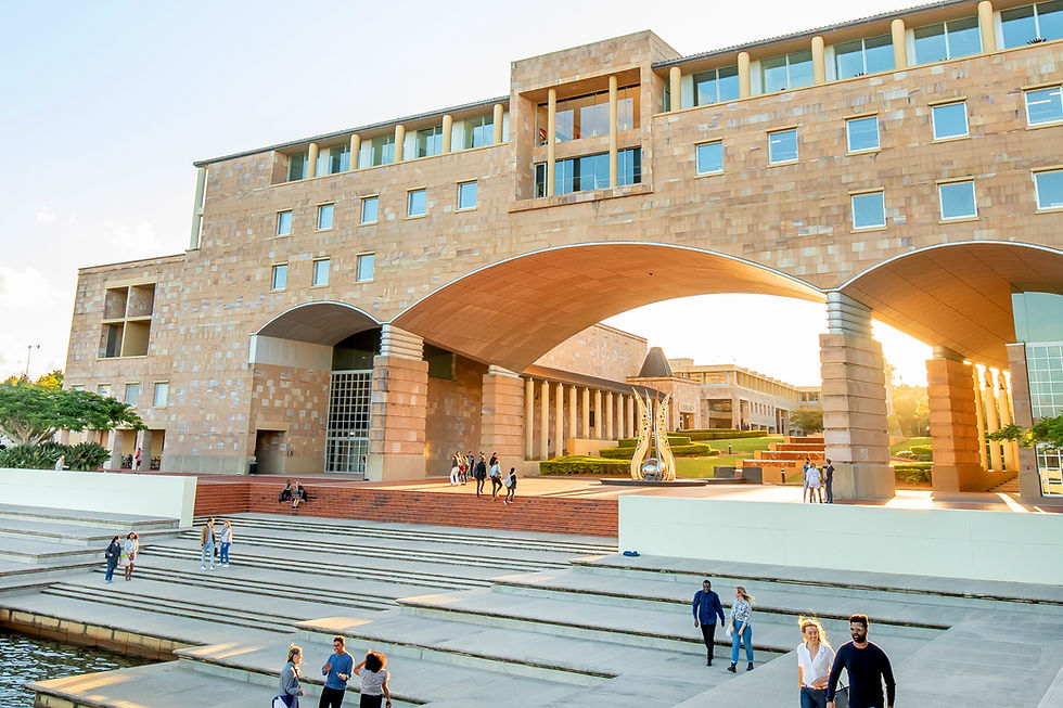 A sandstone building with three arches. Under the main arch there is a sculpture and view of the collonaded stairs.