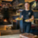 Picture of a waitress brining out two plates of hot homecooked food at Druid Inn Llanferres