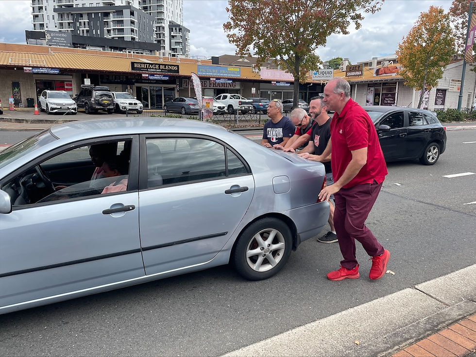 You never know what’s going to happen on a prayer walk! Here, Major Darren Kingston (in red) and other south-west Sydney Salvation Army mission expression leaders and volunteers assist community members whose car had broken down.