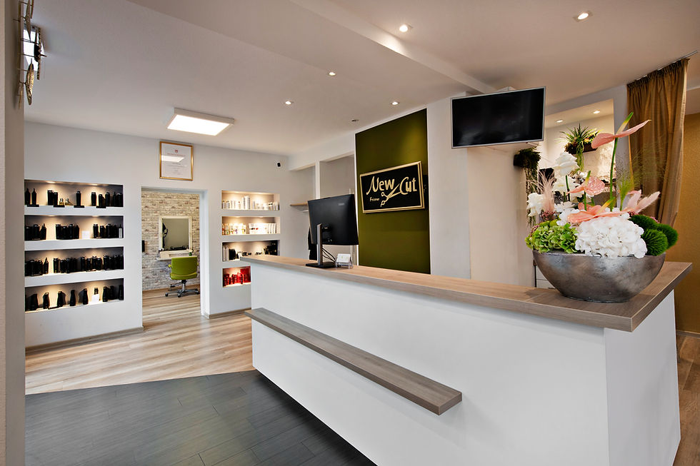 Friseursalon von New Cut mit der Rezeption, dem Logo und einem Regal mit Haarpflege-Produkten