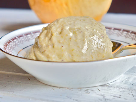 A scoop of homemade mung bean ice cream in a white bowl with red decorative trim, accompanied by a gold spoon.
