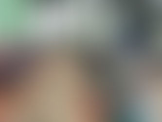 Elderly men and women sit in two long rows on the ground outdoors, each with a jute bag of rice placed beside them, as a volunteer addresses the group during a Lotus Ministry Trust food relief distribution event.