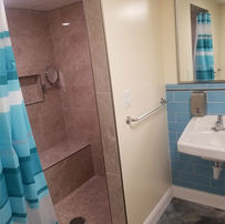 bathroom shower tile, sink, grab bars, water fixtures, and wall decoration inside NYPD pizzaria