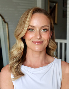 a bride after getting hair and makeup done at her bridal preview. her hair is done in classic waves with a side part