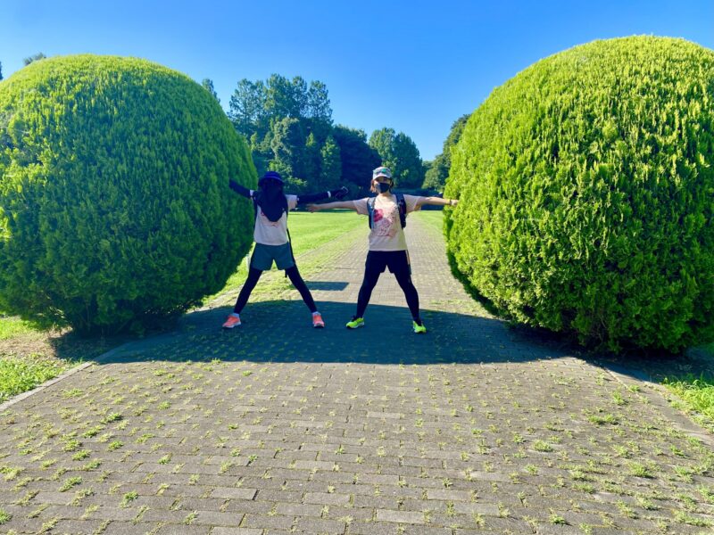 丸い木の間に手を広げて立つ