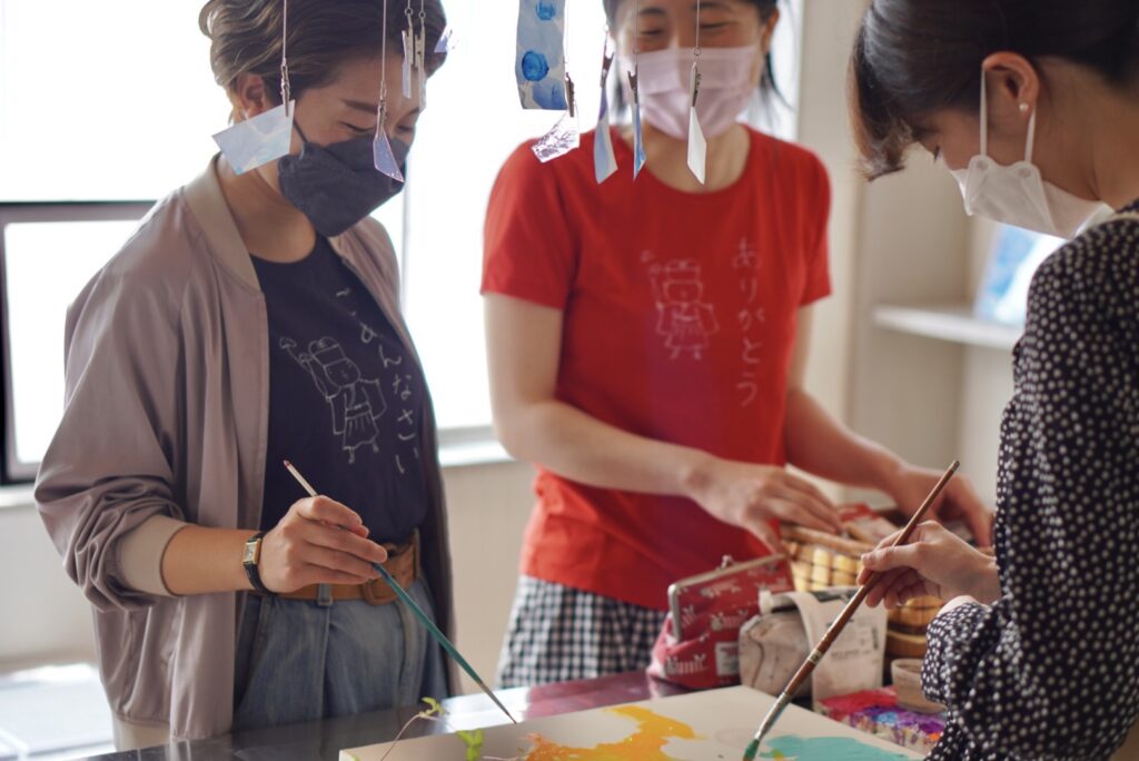 一つのキャンバスに複数人で絵を描く様子