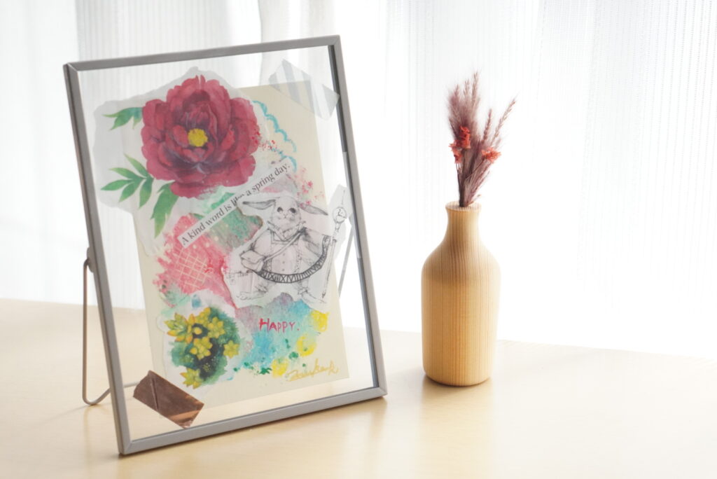 カーテンの前にコラージュしたフレーム作品がある