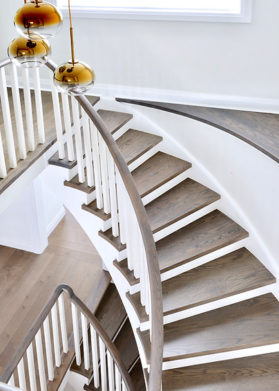 Walnut Colored Staircase with White Risers, Chandelier and Curved Feature