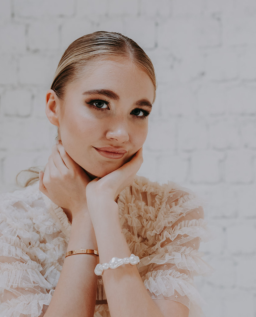 Eine Person mit den Händen am Kinn