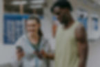 Woman and man at a gym and looking at a fitness app