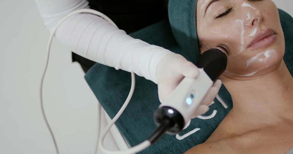 Aesthetician applying radio frequency wand to client’s cheek