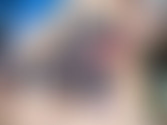 The outside of Brownstone Spa in Pickens, a two-story brick building with purple-gray wood columns out front.