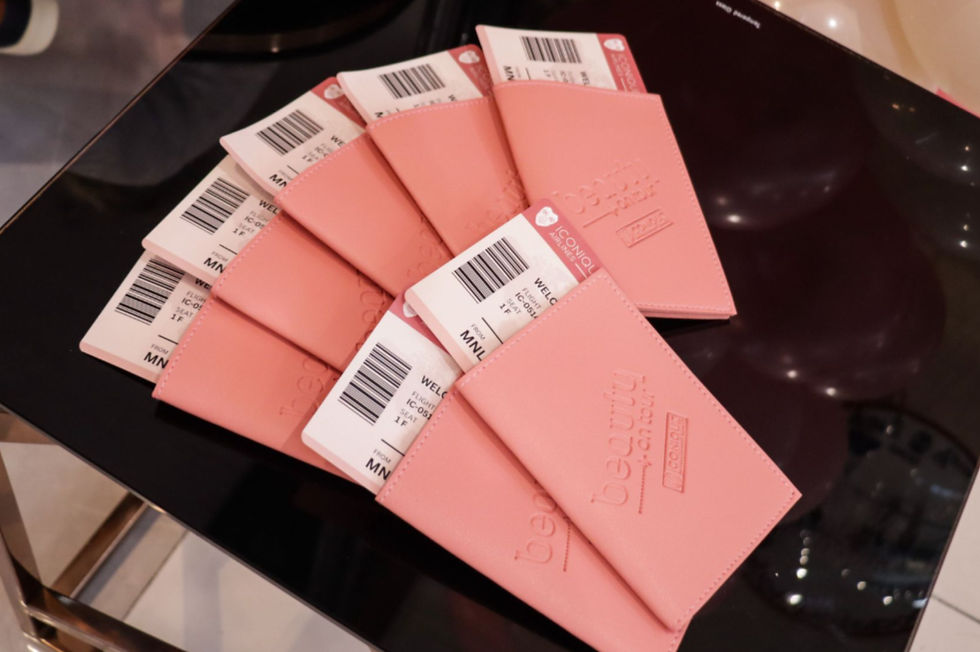 A photo of the ICONIQUE Beauty giveaway: passport covers with inserted plane ticket-inspired invitations