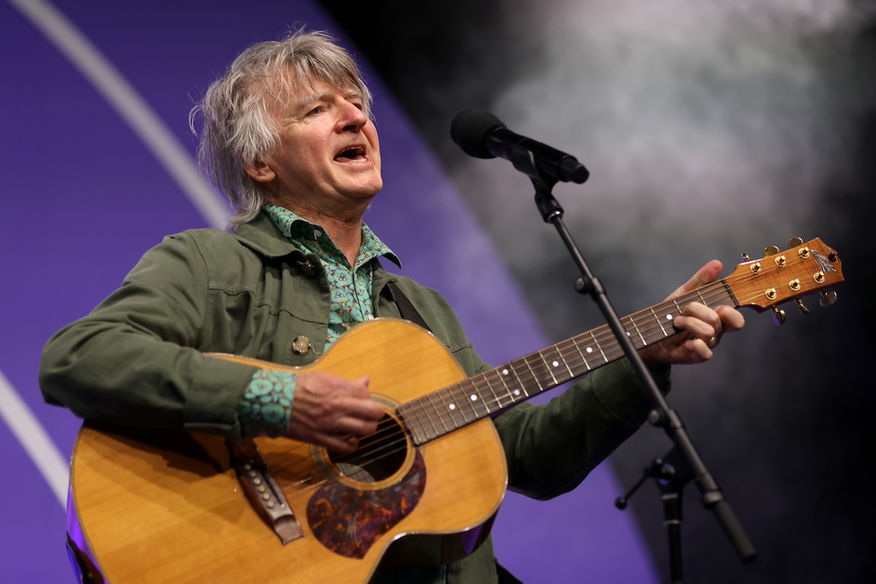 Neil Finn from Crowded House playing an acoustic guitar
