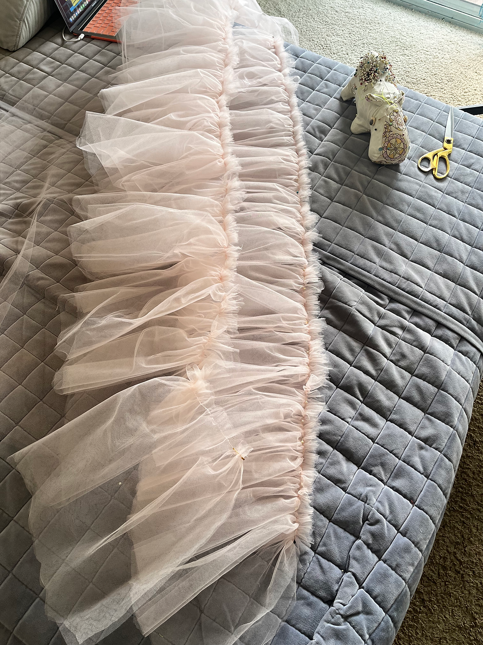 ruffled tulle laying on rows on a bed with pincushion and scissors