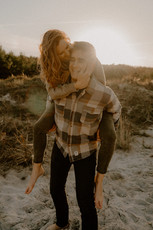 Pärchen nimmt sich auf Fischland Darss Huckepack. Hat Spaß dabei!