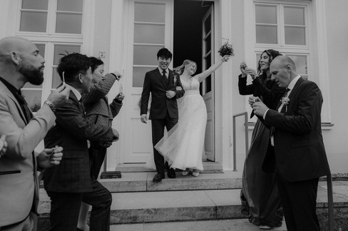 Auszug bei Hochzeit im Gutshaus Stolpe in Greifswald. Fröhlicher Moment vom Brautpaar mit den Gästen. 