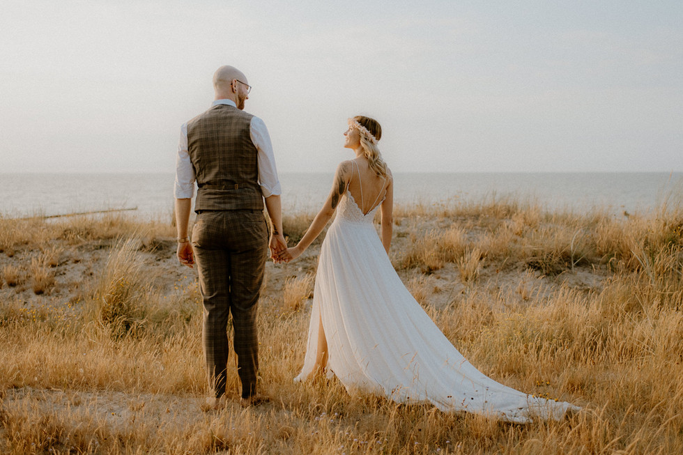 Paar schaut sich zärtlich in die Augen, im Hintergrund die Ostsee. Paarfotografie voller Liebe in Ahrenshoop.