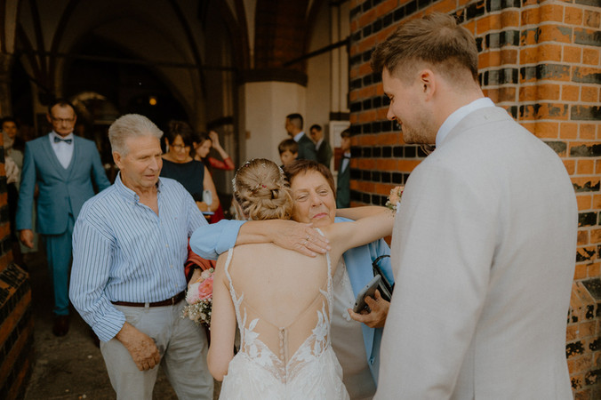 Brautpaar wird von Großeltern beglückwünscht. Sommerliche Hochzeit auf dem alten Markt in Stralsund. 