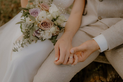 Details am Hochzeitstag in Anklam : Pärchen hält Händchen auf einer Bank. 