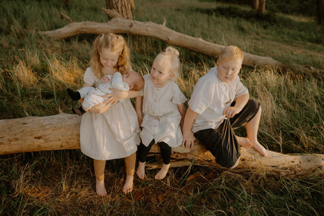 Authentische Kinderfotografie in Gelbensande. Geschwister halten liebevoll ihren Bruder im Arm. Monique hält diese Momente als Familienfotografin in Gelbensande fest.