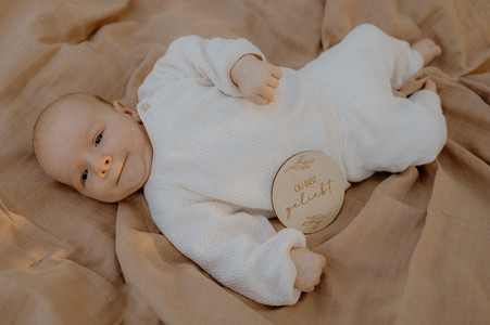 Neugeborenenfotos Duvendiek : Neugeborens liegt auf einer hellen Decke