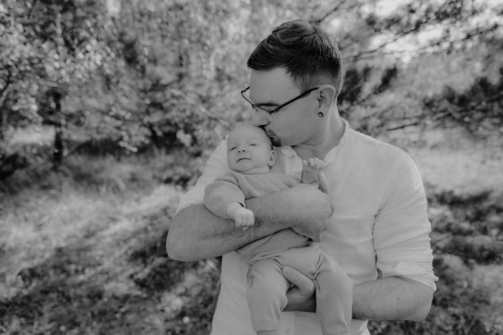 Papa Sohn Fotoshooting in Stralsund - Vater wird beim Kuscheln mit seinem Sohn fotografiert - Babyfotografie voller Nähe in Negast