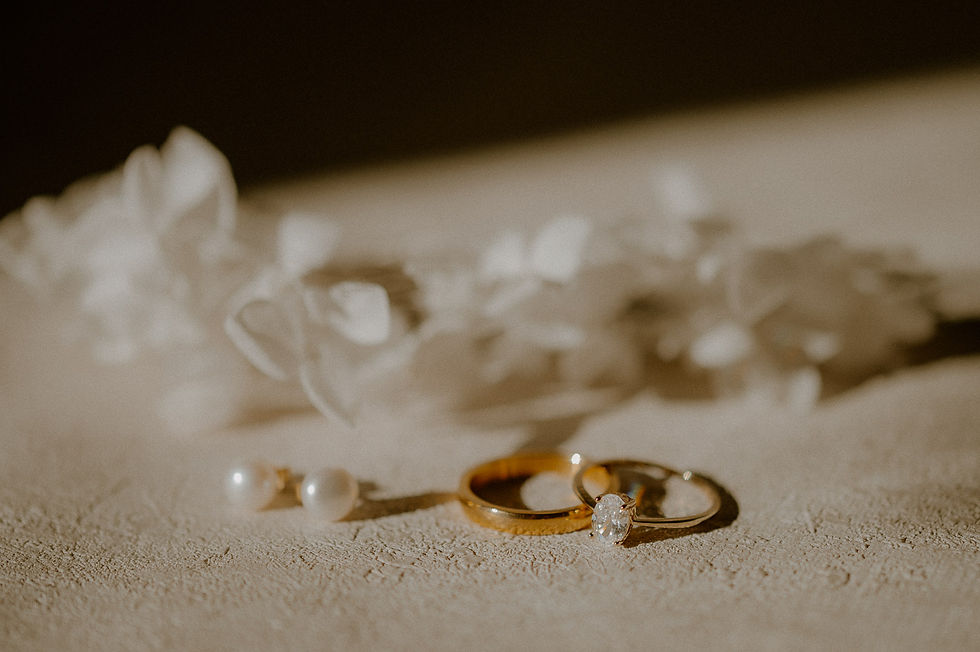 Perlenohrringe und goldene Eheringe im Sonnenlicht. Fotograf begleitet Hochzeit im Grand Hotel Heiligendamm.